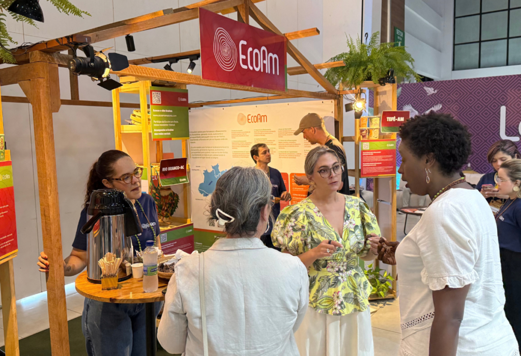 Visitantes conversam com a equipe do EcoAm no estande do Impact Minds 2026